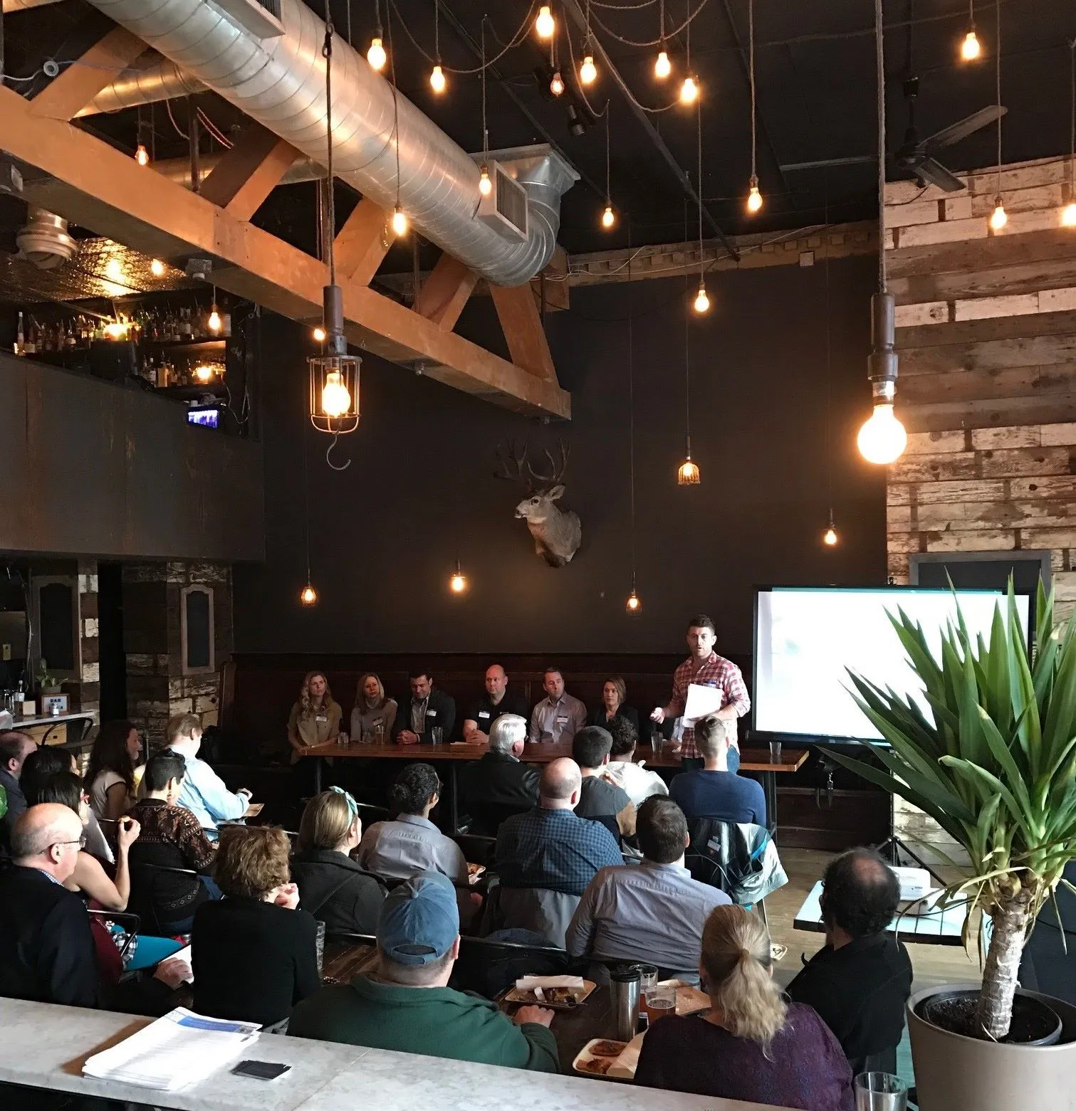 Matt Holmes leading a How to CoBuy a Home session to a full room in Seattle, with a panel